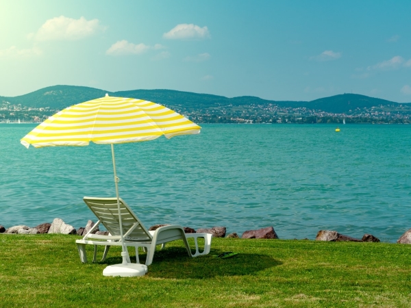 zdjęcie leżaka i parasola nad jeziorem
